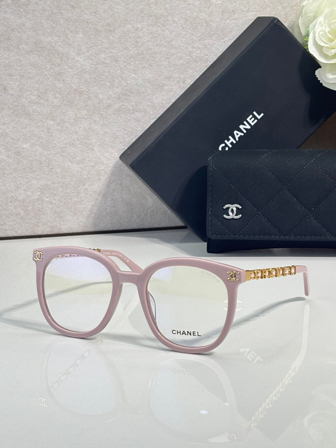 Light pink rectangular eyeglasses with gold-tone temple accents and Chanel logo