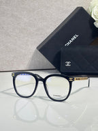Dark blue rectangular eyeglasses with gold accent temple and Chanel logo on lens