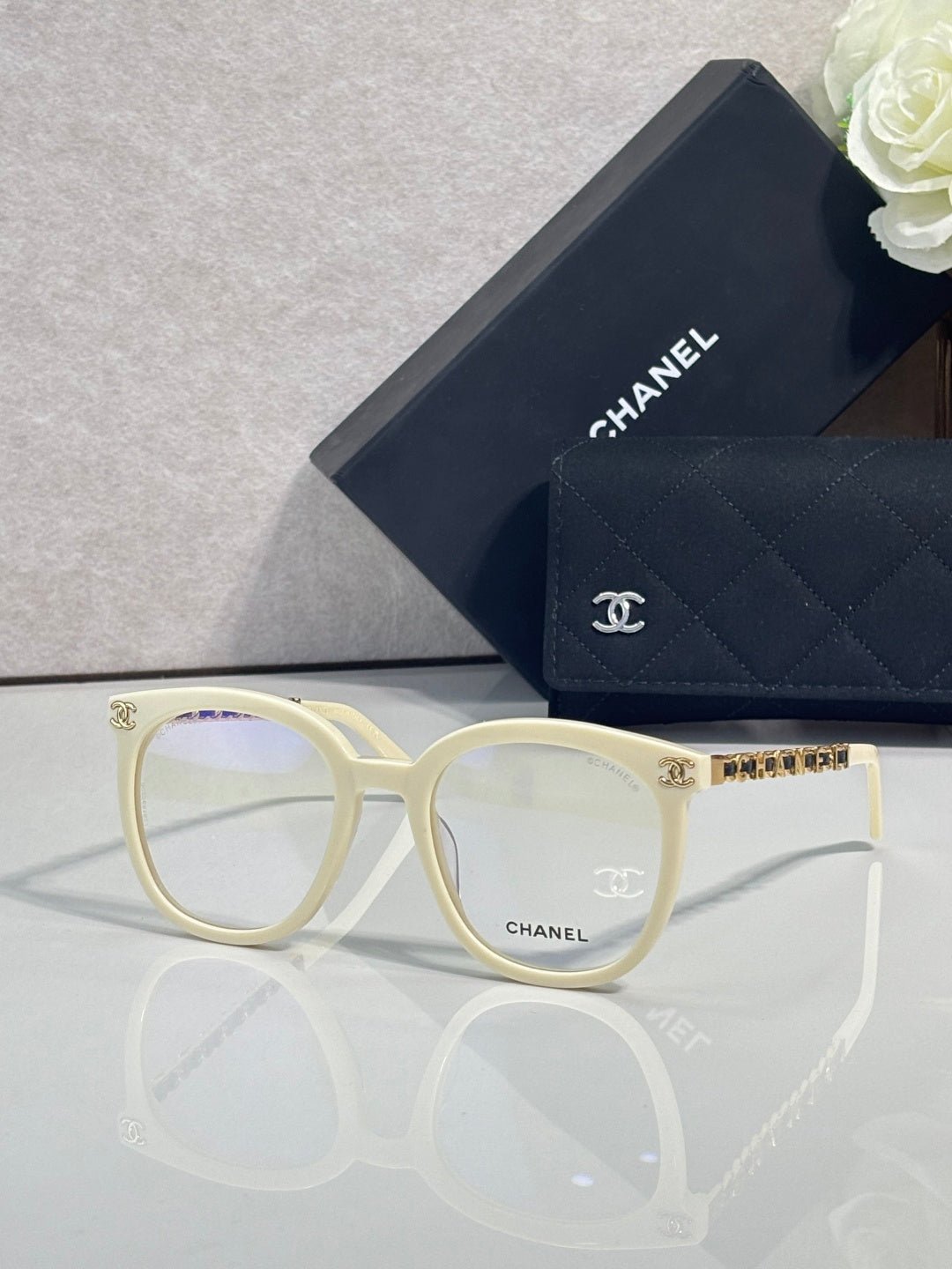 Cream rectangular eyeglasses with gold-tone temple accents and Chanel logo