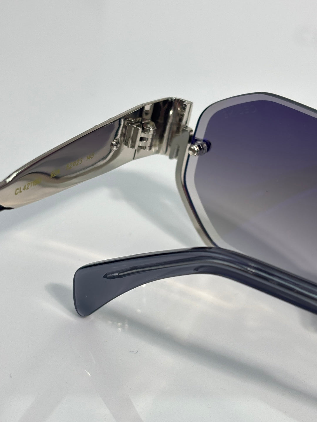 Celine glasses close-up of metal hinge and blue-tinted lens