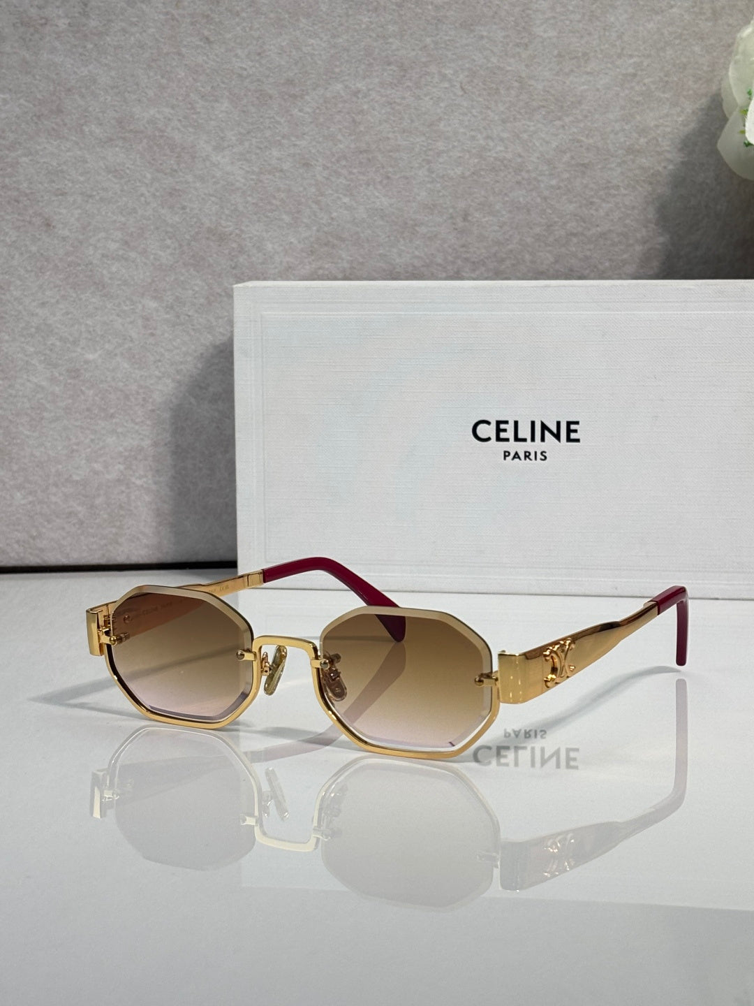 Celine glasses with gold-tone frame and burgundy temple, dark tinted lenses