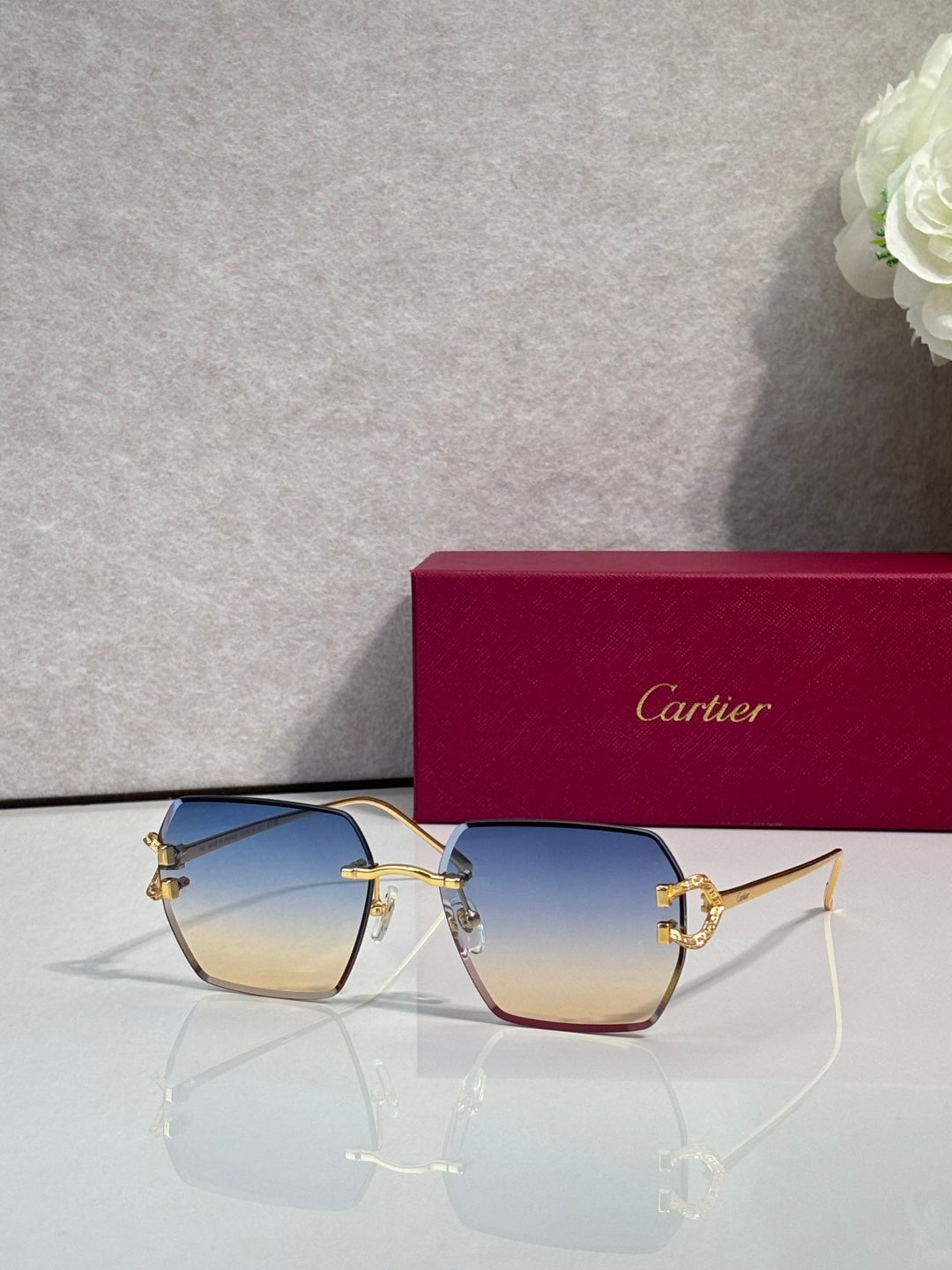 Cartier glasses with blue-to-yellow gradient lenses and gold-tone cat-eye frame