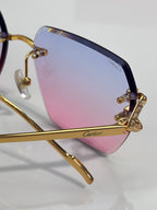 Cartier glasses close-up: gold frame with rhinestone detail and blue-pink lenses