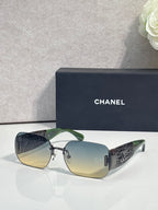 Chanel sunglasses with light yellow gradient lenses and gold metal frame, textured temple panels