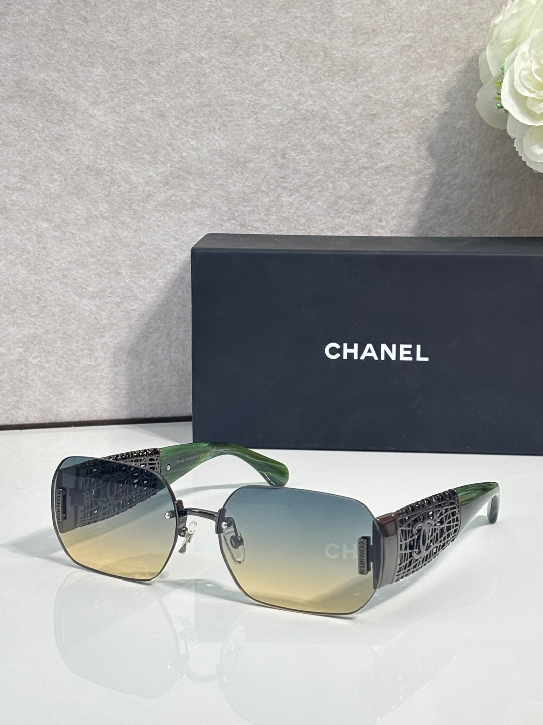 Chanel sunglasses with light yellow gradient lenses and gold metal frame, textured temple panels