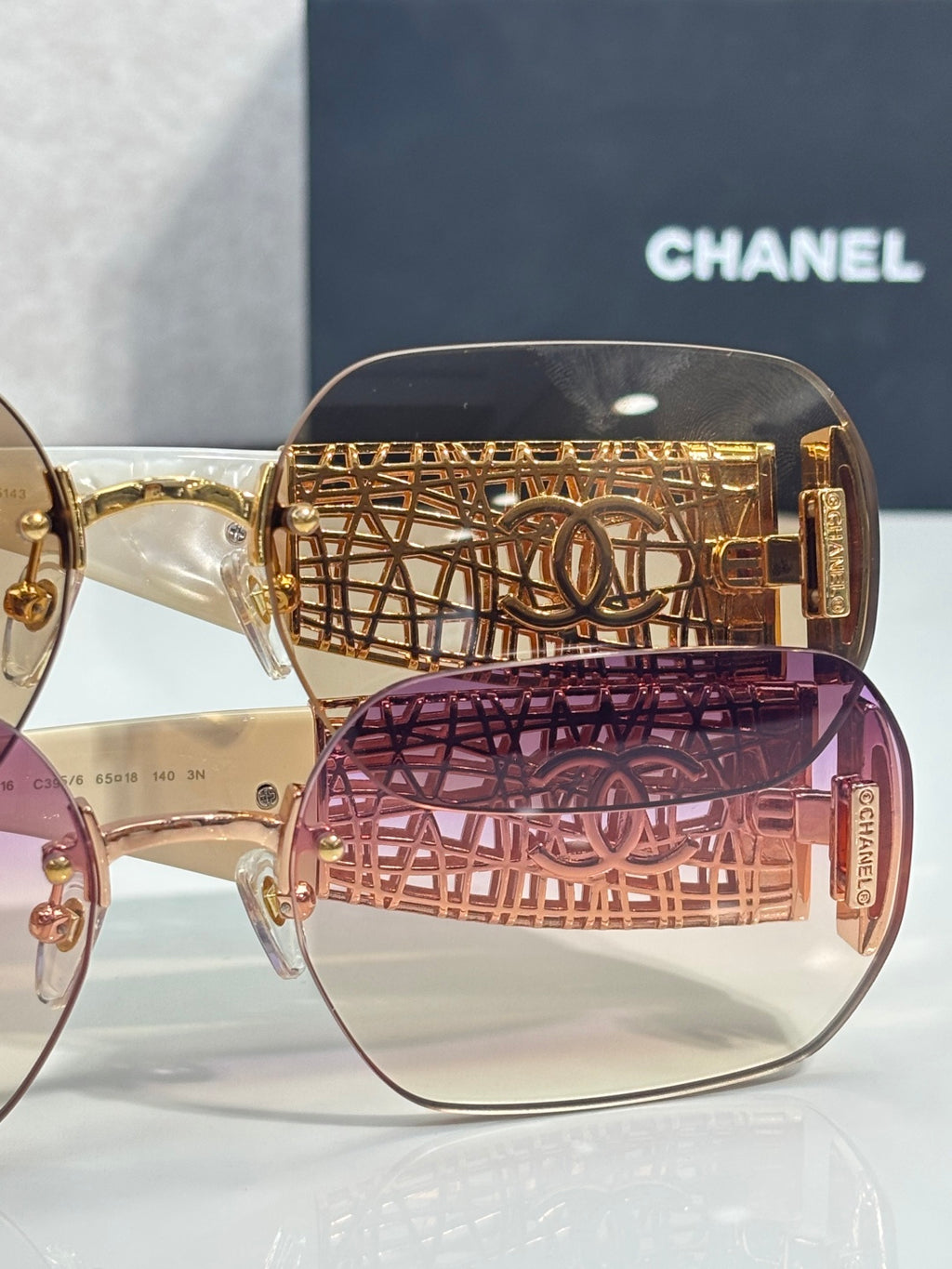 Chanel sunglasses close-up: gold lattice temple with CC logo and tinted lenses