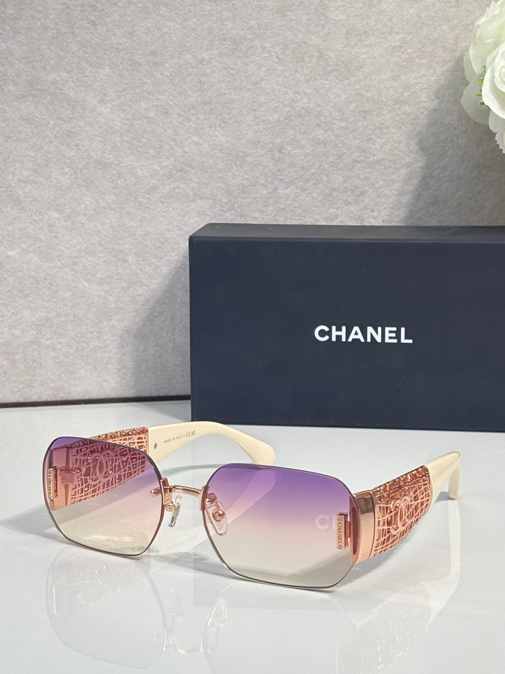 Chanel sunglasses with purple gradient lenses and gold metal frame, textured temple panels