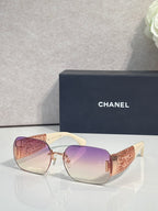 Chanel sunglasses with purple gradient lenses and gold metal frame, textured temple panels