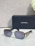 Chanel sunglasses with blue gradient lenses and gold metal frame, textured temple panels