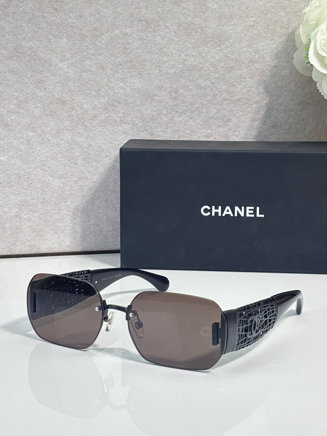 Chanel sunglasses with brown gradient lenses and gold metal frame, textured temple panels