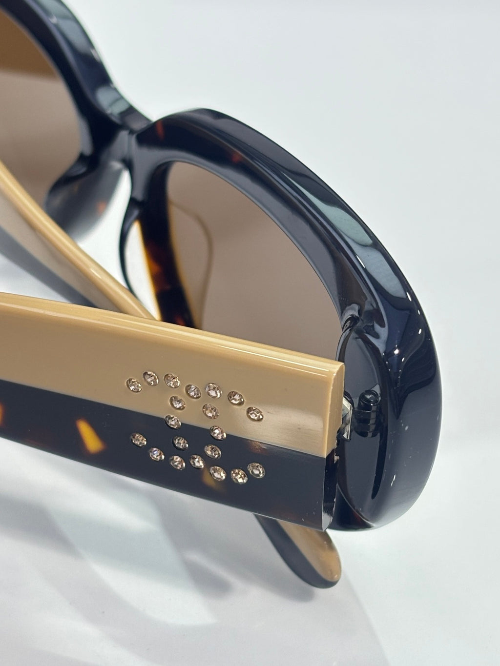 Gold and black sunglass temple with rhinestone row and lens edge