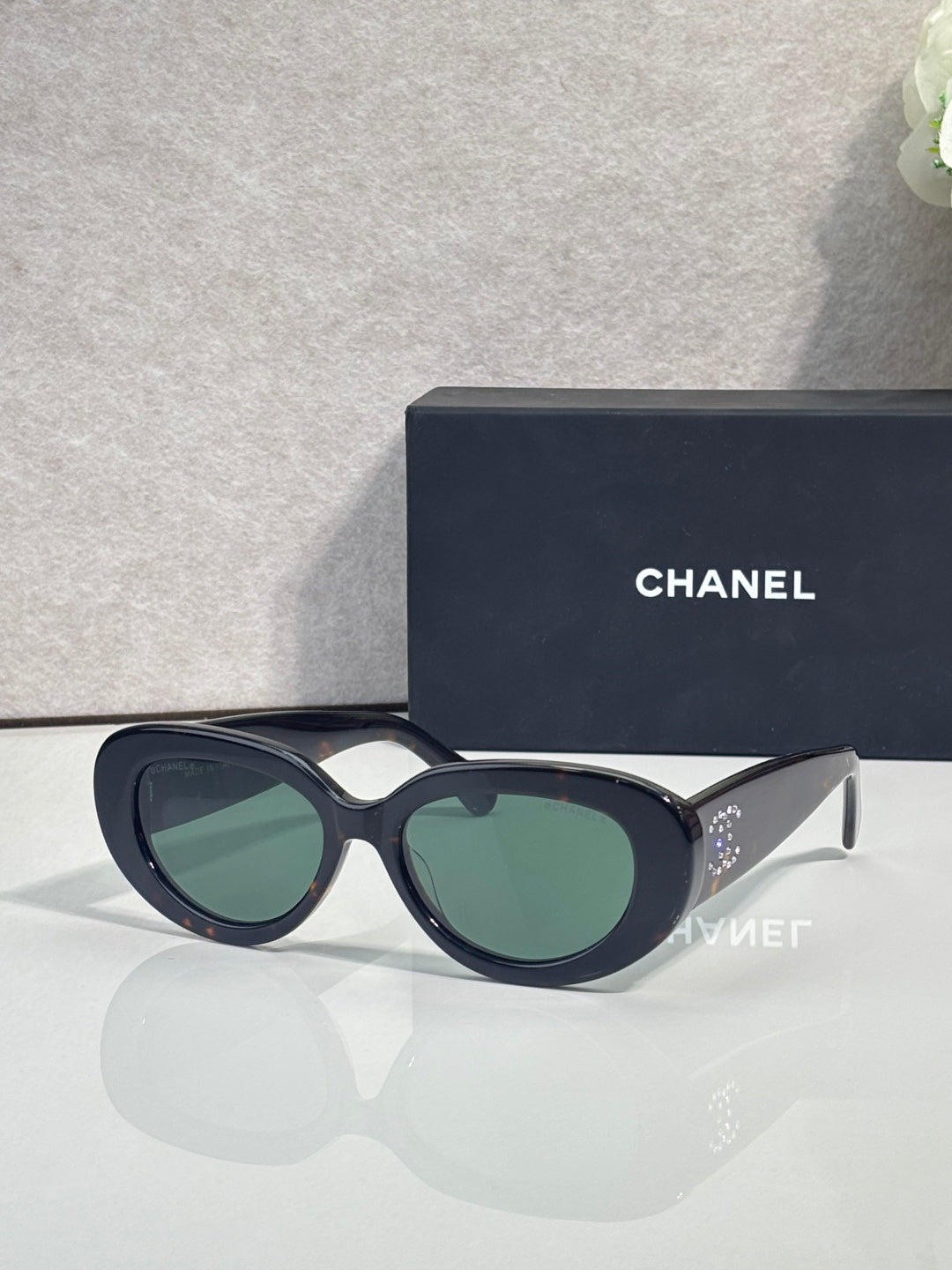 Dark navy round sunglasses with green-tinted lenses and light accent bridge