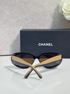 Navy cat-eye sunglasses with tan lenses and gold-tone side arms