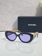 Navy round sunglasses with purple-tinted lenses and gold-tone side arms
