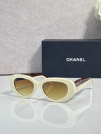 Cream cat-eye sunglasses with gold-tinted lenses and gold-tone side arms