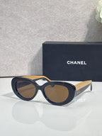 Dark navy round sunglasses with brown lenses and tan side arms