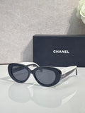 Navy round sunglasses with dark lenses and white accent bridge