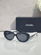 Navy round sunglasses with dark lenses and white accent bridge