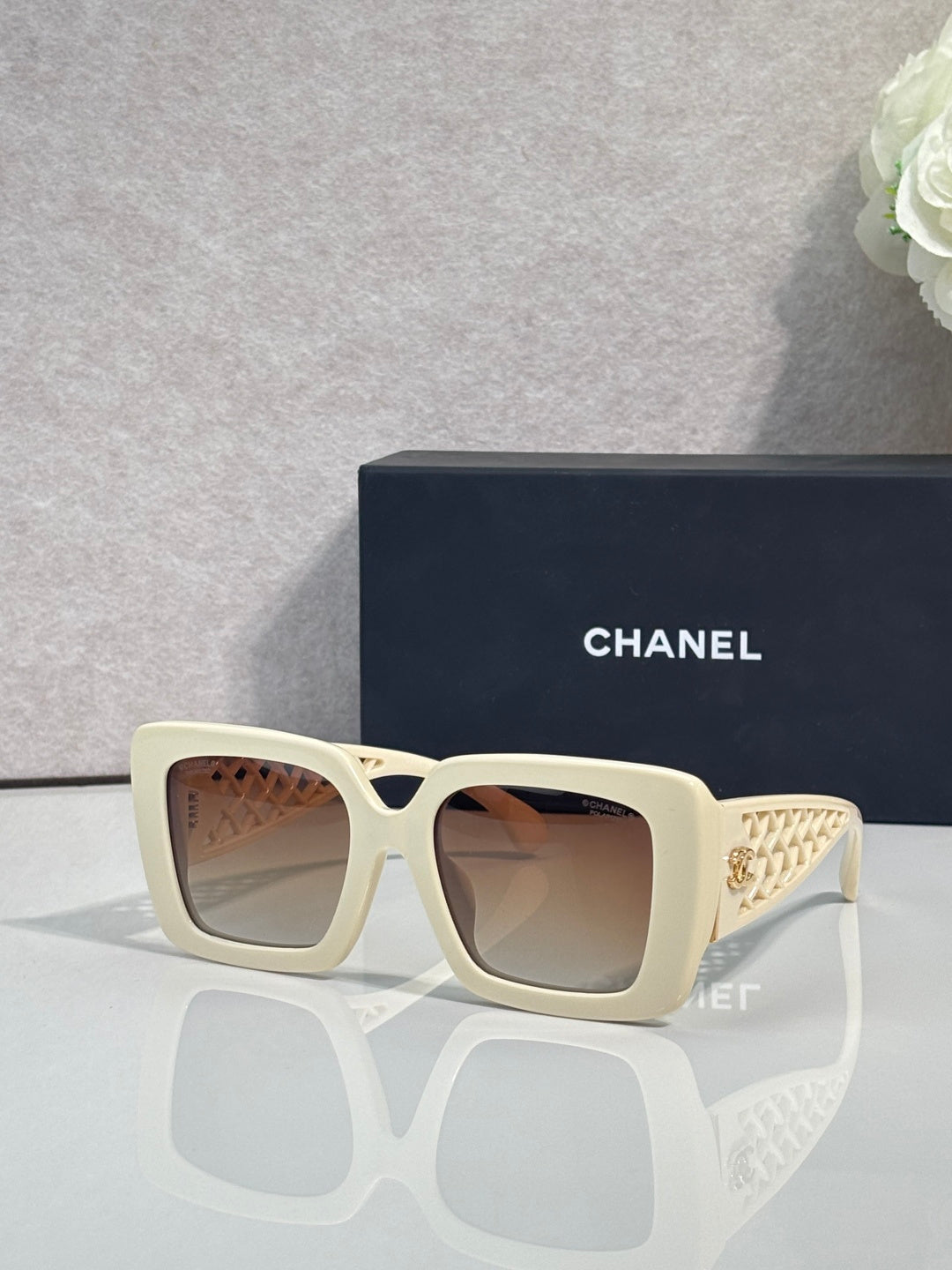 Chanel square sunglasses with light cream frame and gold logo detail on temple
