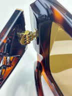Chanel sunglasses temple close-up with gold logo accent on tortoiseshell frame