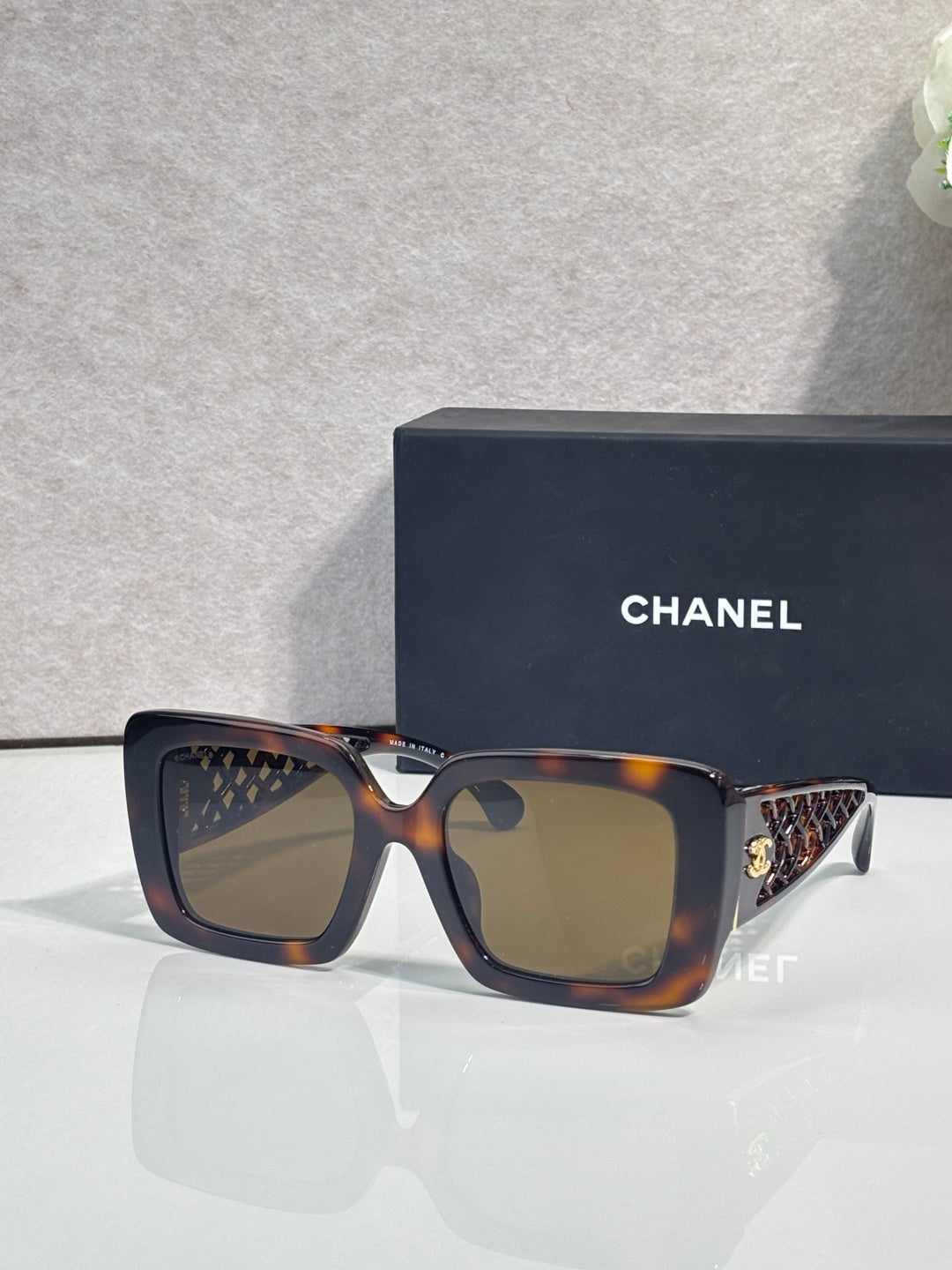 Chanel square sunglasses with tortoiseshell frame and gold logo detail on temple