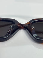 Chanel sunglasses close-up with dark gradient lenses and tortoiseshell frame