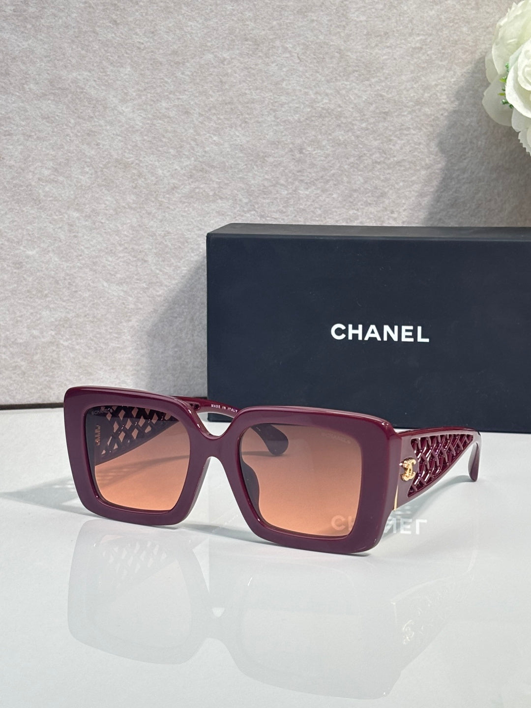 Chanel square sunglasses with burgundy frame and gold logo detail on temple