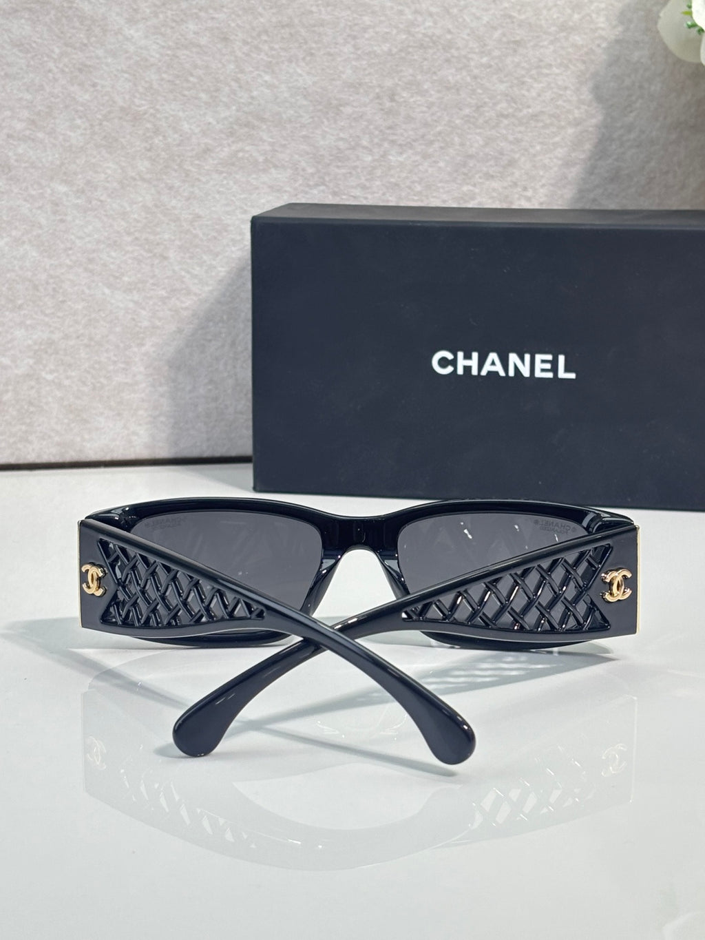 Navy sunglasses with dark lenses, quilted-pattern temples and gold-tone logo details