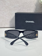 Navy sunglasses with dark lenses, quilted-pattern temples and gold-tone logo details