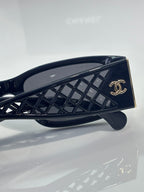 Navy sunglasses temple close-up with gold CC logo on lattice-pattern arm