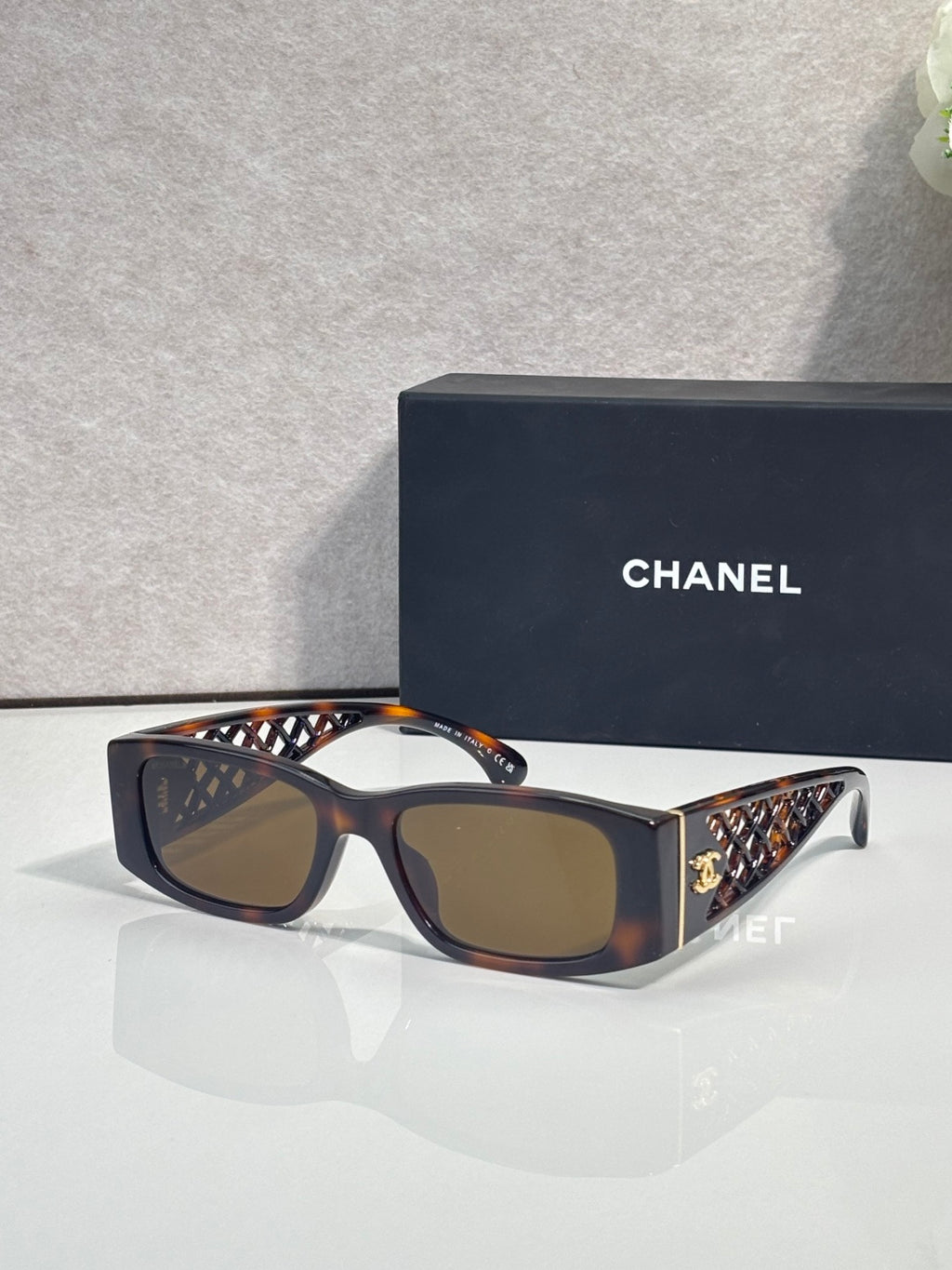 Dark sunglasses with brown lenses and geometric-pattern temples