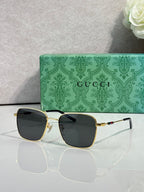 Gucci sunglasses with dark green-tinted lenses and gold-tone frame