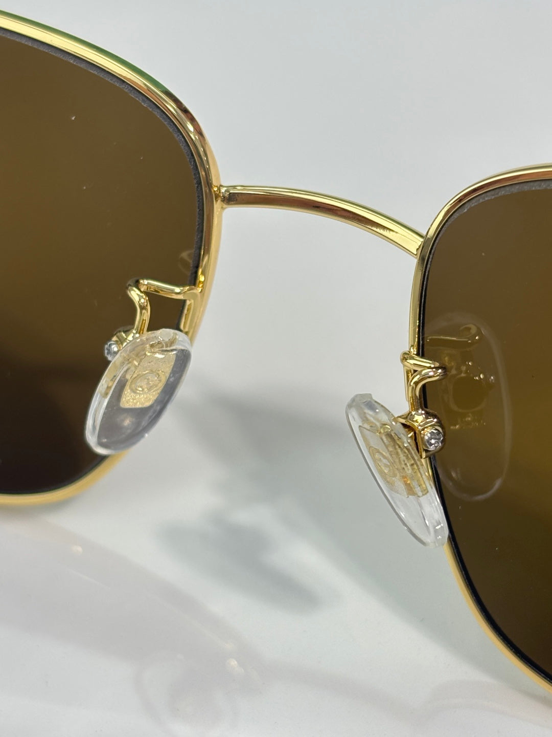 Gucci sunglasses close-up: gold frame detail and dark lens