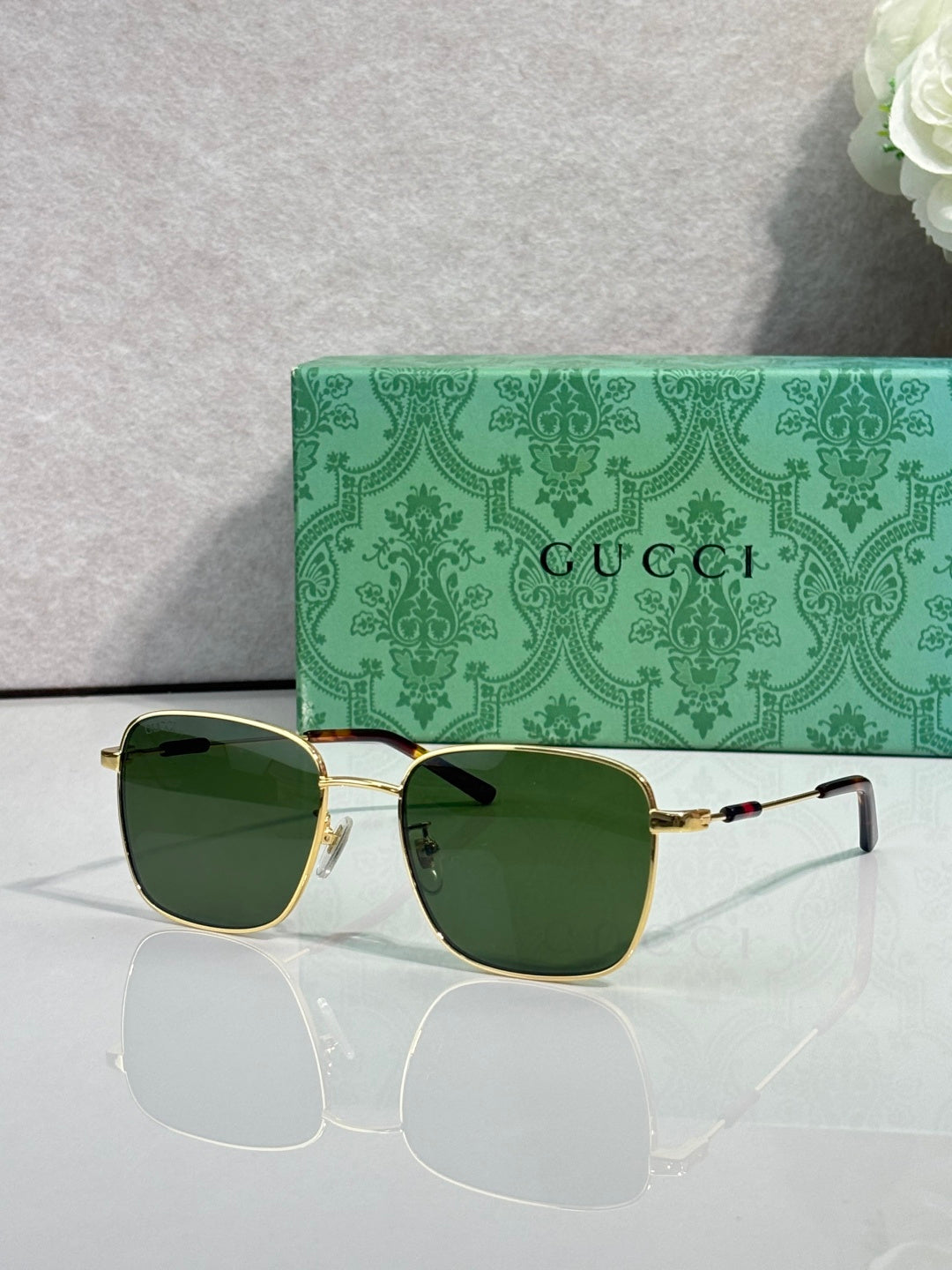 Gucci sunglasses with dark lenses and gold-tone frame