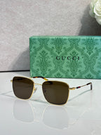 Gucci sunglasses with brown-tinted lenses and gold-tone frame