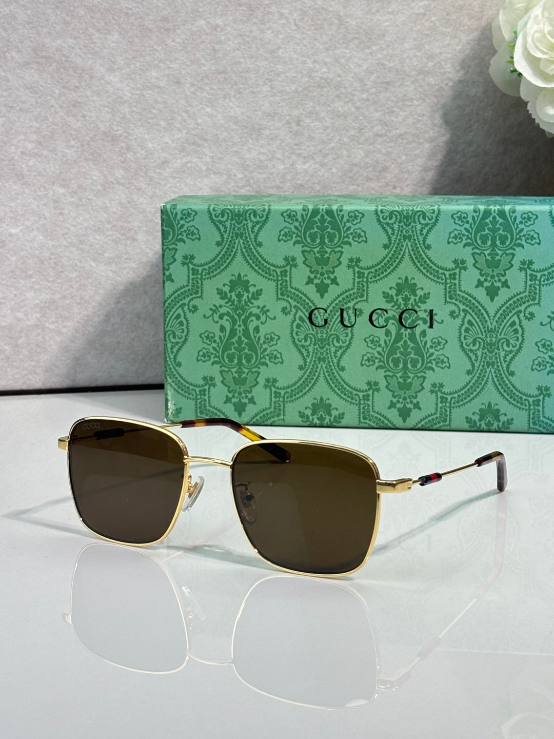 Gucci sunglasses with brown-tinted lenses and gold-tone frame