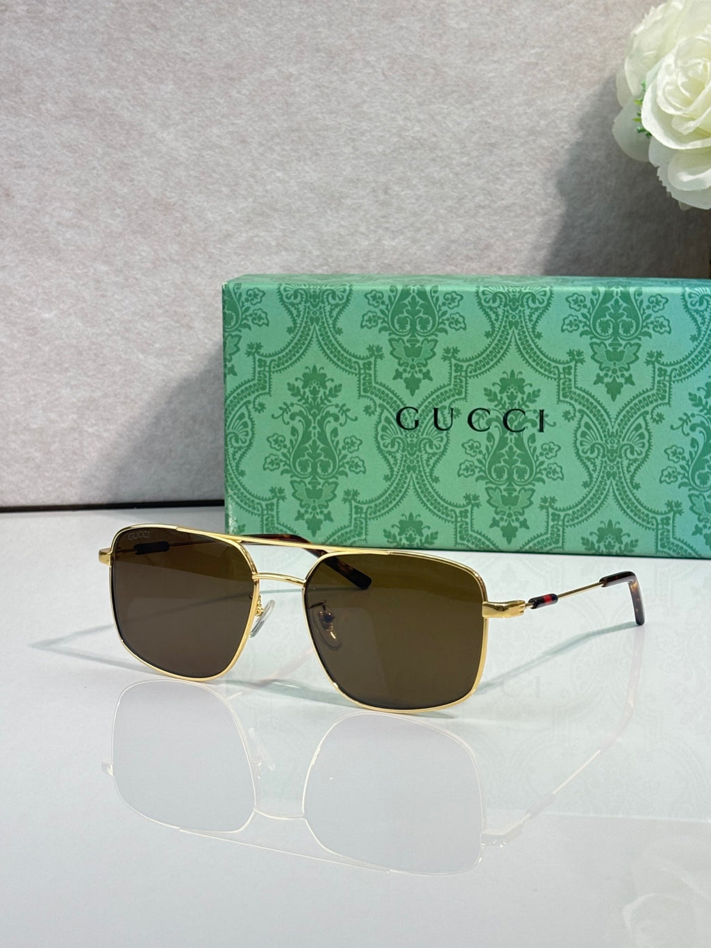 Gucci sunglasses with gold-tone frame and dark tinted lenses, square cat-eye shape