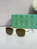 Gucci sunglasses with gold-tone frame and dark tinted lenses, square cat-eye shape