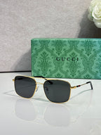 Gucci sunglasses with gold-tone frame and dark tinted lenses, wide cat-eye style
