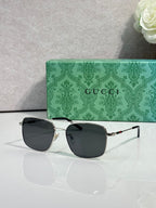 Gucci sunglasses with dark frame and dark tinted lenses, square cat-eye style