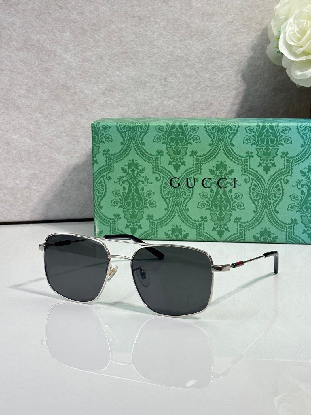 Gucci sunglasses with dark frame and dark tinted lenses, square cat-eye style
