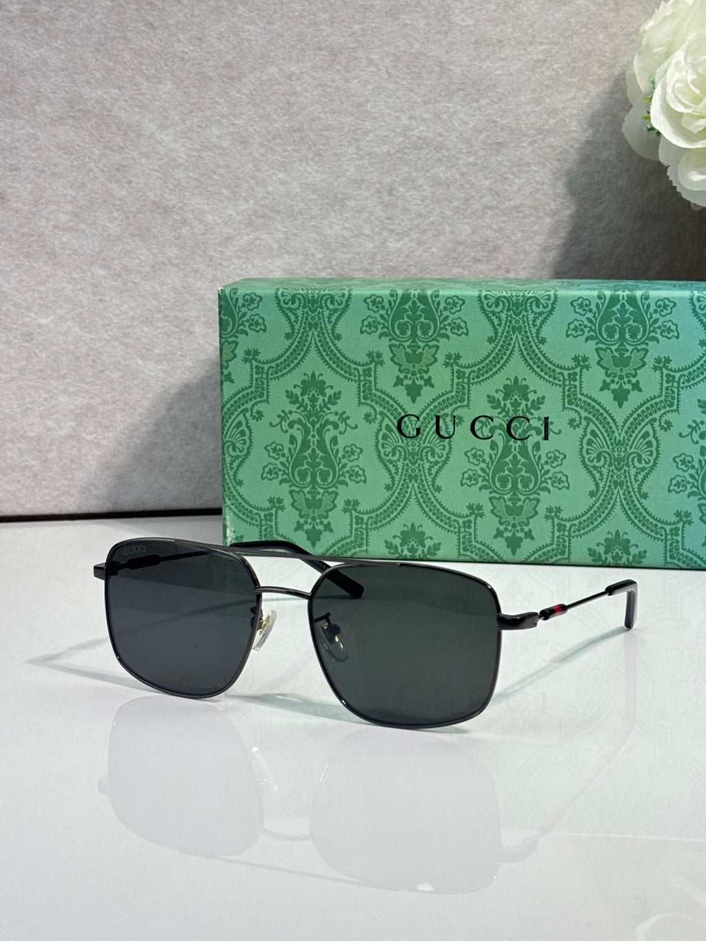 Gucci sunglasses with black frame and dark tinted lenses, wide cat-eye shape