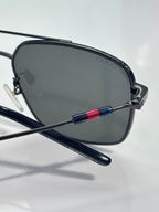 Gucci sunglasses close-up of dark lenses with navy temple and red-blue stripe accents