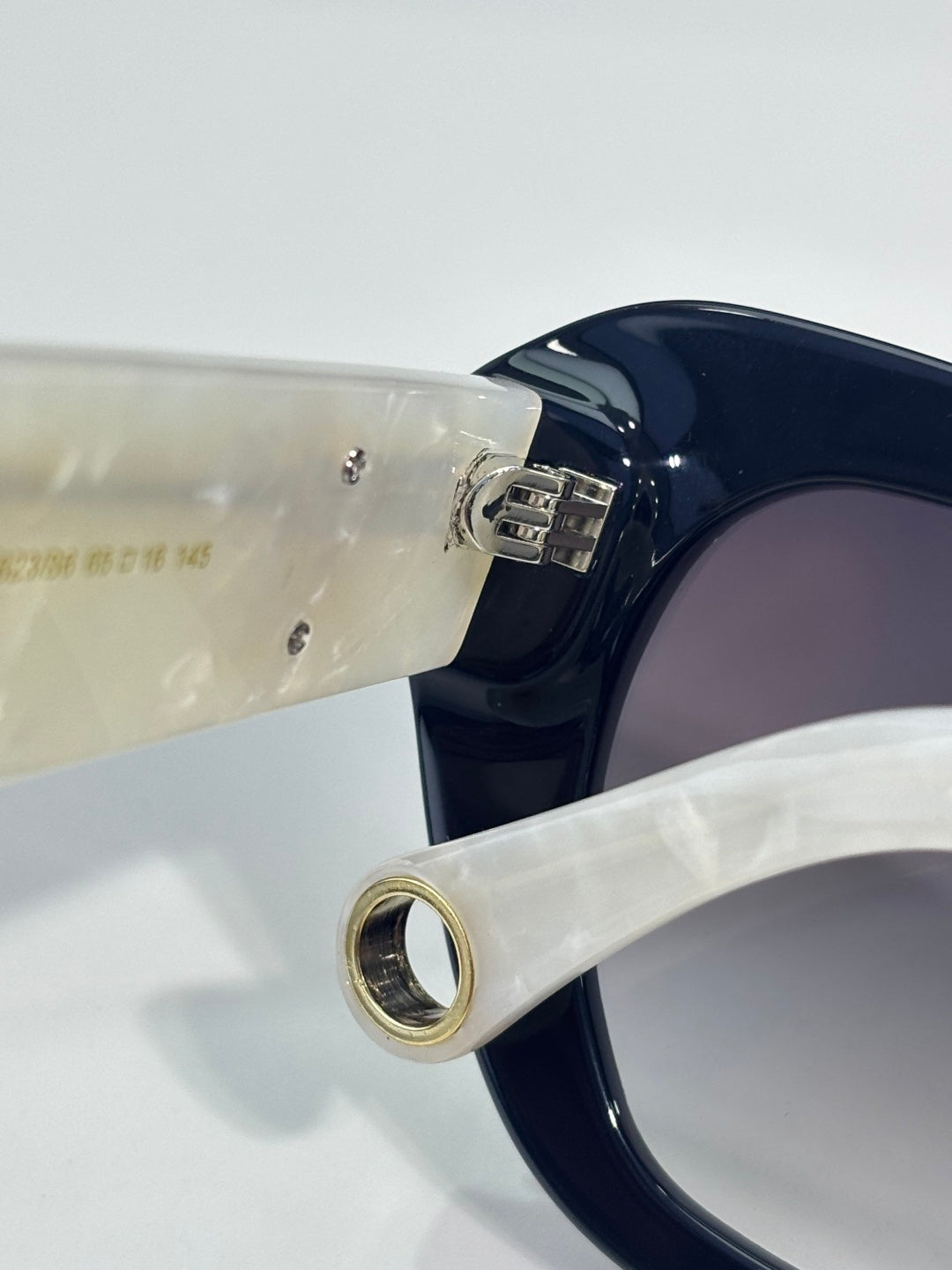 Chanel sunglasses temple close-up with cream arm and gold logo hardware