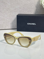Chanel cat-eye sunglasses with light yellow frames and gold logo details