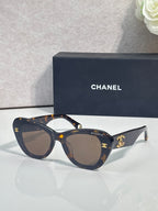 Chanel cat-eye sunglasses with dark frames, gold logo details, tinted lenses