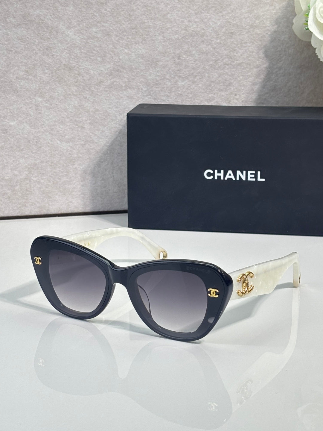 Chanel cat-eye sunglasses with dark blue frames and gold logo on temple