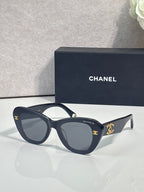 Chanel cat-eye sunglasses with dark navy frames and gold logo on temple