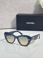 Chanel cat-eye sunglasses with dark navy frames and gold logo hardware