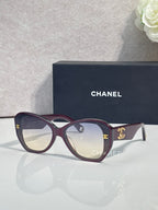 Navy Chanel sunglasses with gold logo on temples and dark tinted lenses